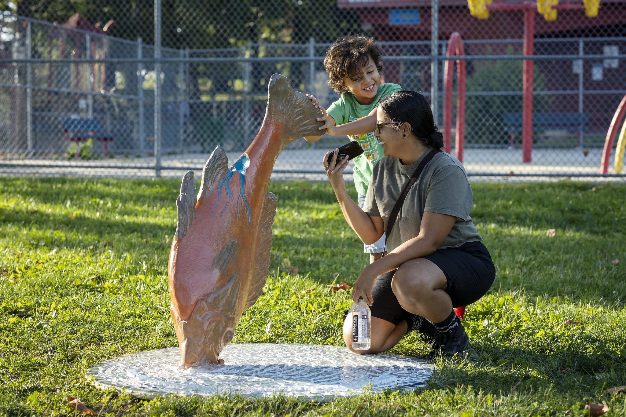 Learning Trail fish sculpture, woman and child